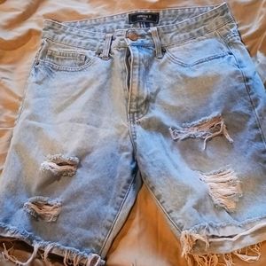 Mens cut off light blue holey jeans.